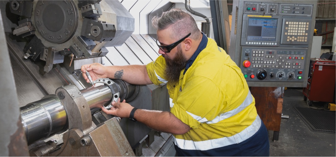 ACR North machinist working at a CNC lathe in the Beenleigh workshop