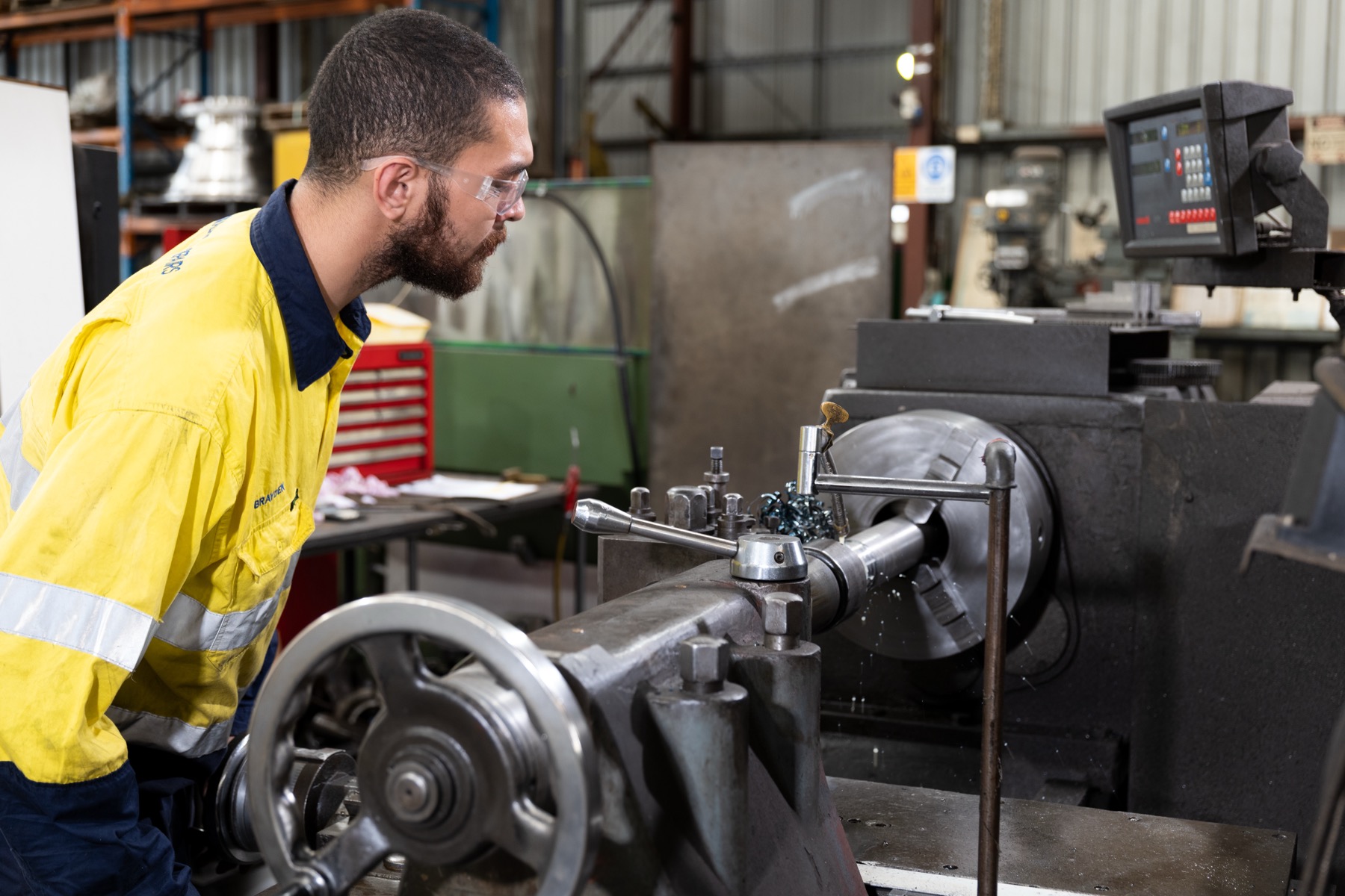 ACR North machinist turning a shaft on a lathe in the Beenleigh workshop