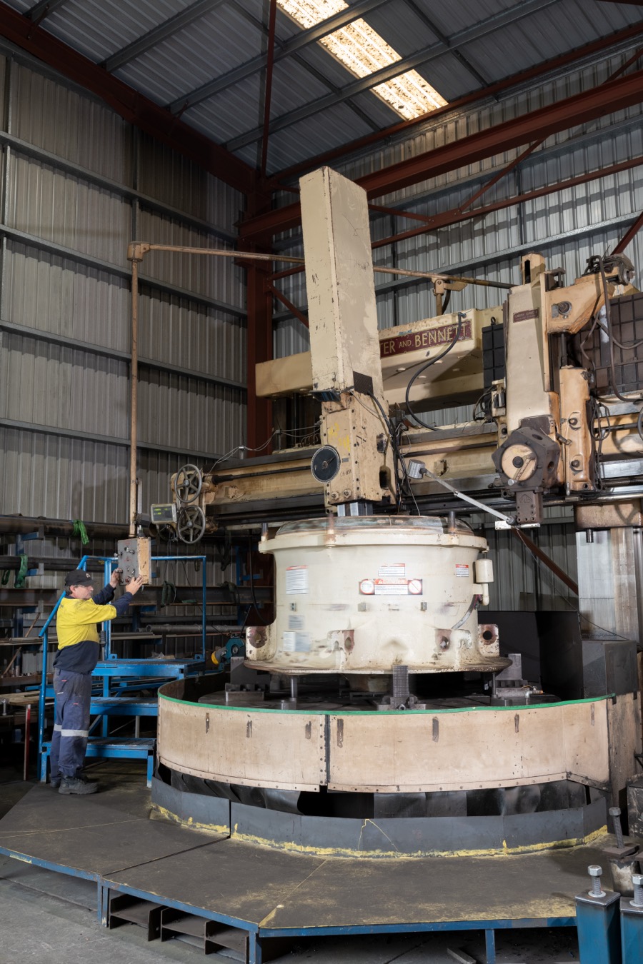 Operator setting up a cone crusher component on the vertical borer